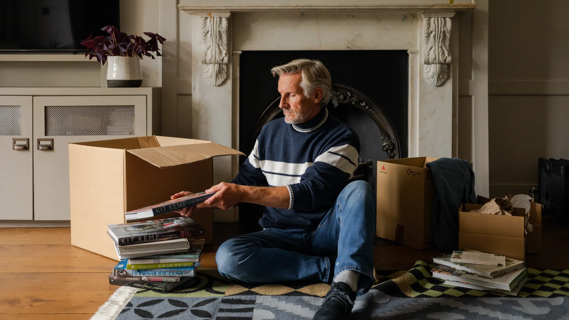man packing boxes in front of a fireplace