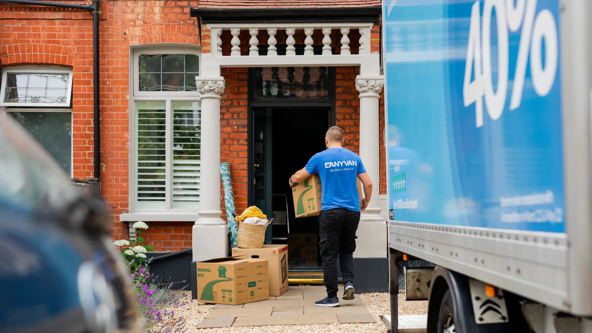 removals man carrying a box into a house