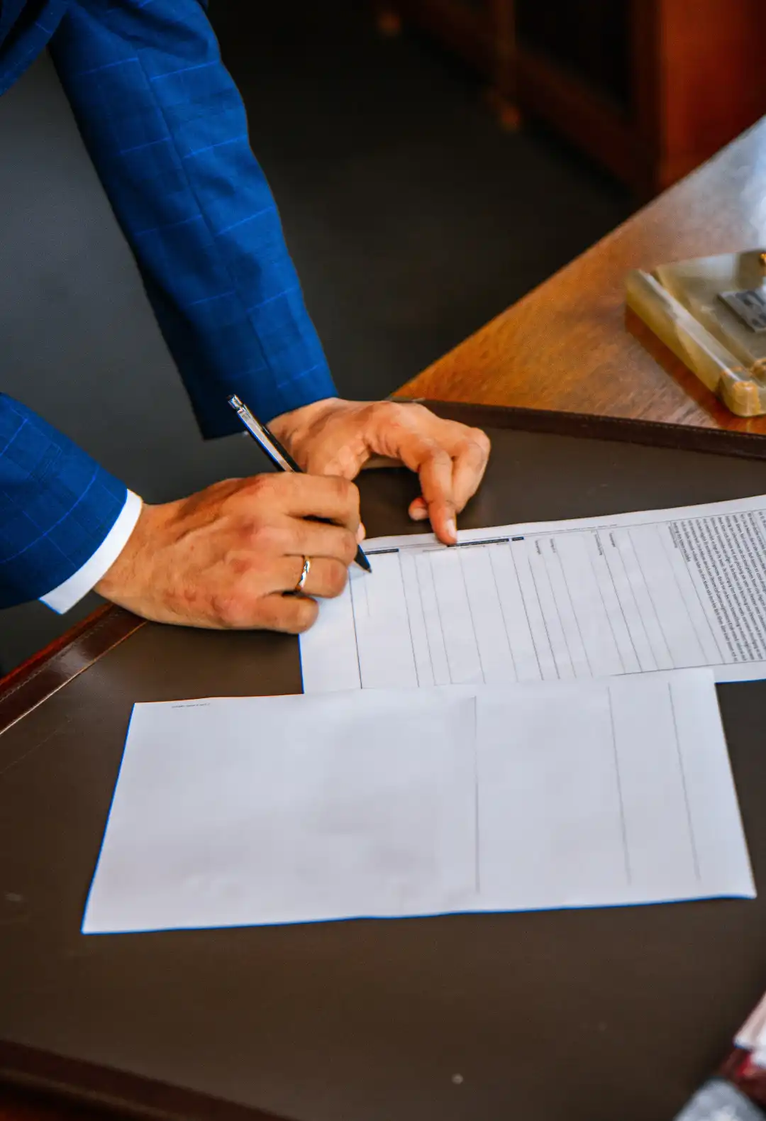 suited man signing paper